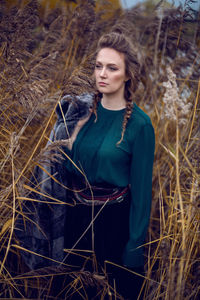 Fashionable woman in a green sweater and a long skirt keeps the fur