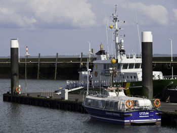 Ship moored at harbor against sky