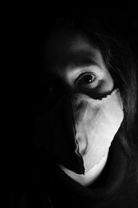 Close-up portrait of woman covering face in darkroom