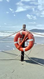 Lifeguard hut on beach against sky