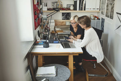 Female architects discussing over solar product at home office