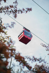 Low angle view of overhead cable car against sky