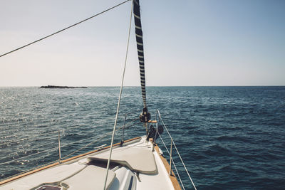 Sailboat sailing on sea against clear sky