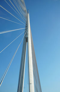 Low angle view of suspension bridge against blue sky