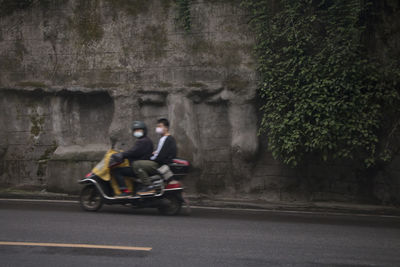 People riding motorcycle on road