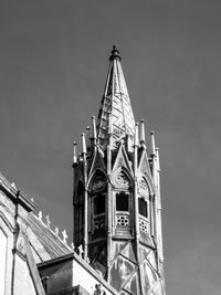 Low angle view of clock tower amidst buildings against sky