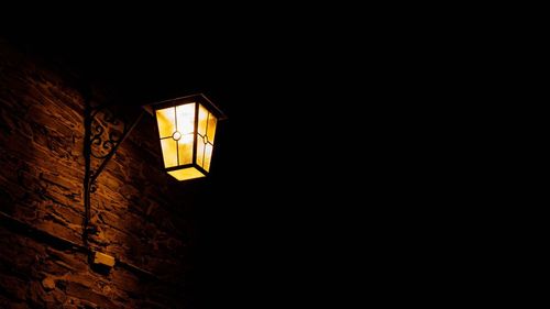 Low angle view of illuminated lamp at night