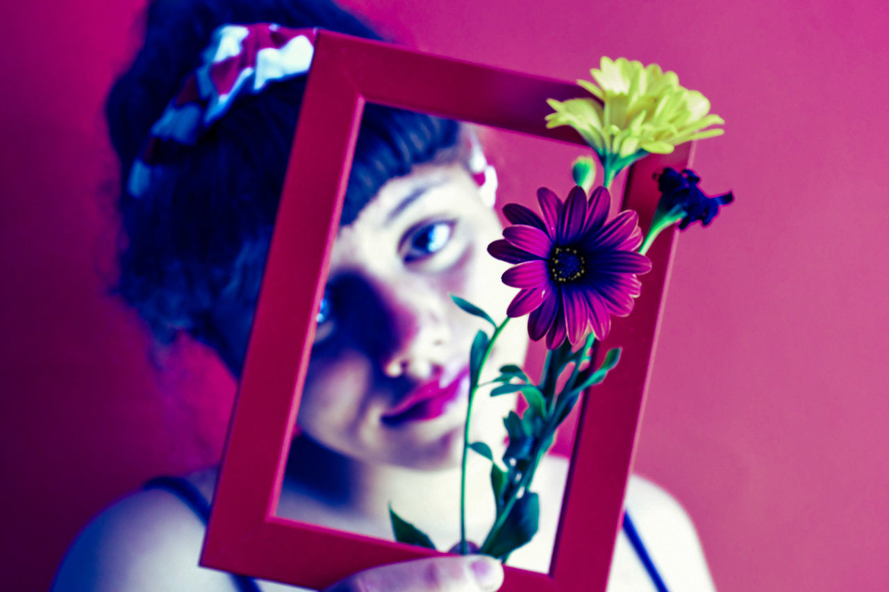 PORTRAIT OF WOMAN WITH PINK FLOWER