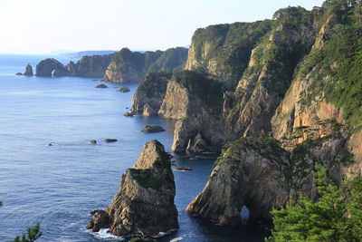 Rock formations in sea against sky