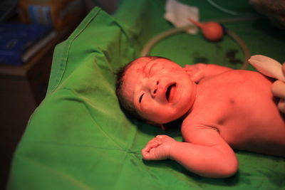 Newborn baby lying on bed