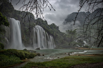 Scenic view of waterfall against sky