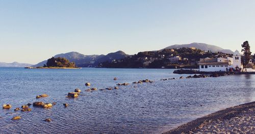 Scenic view of sea and mountains against clear sky