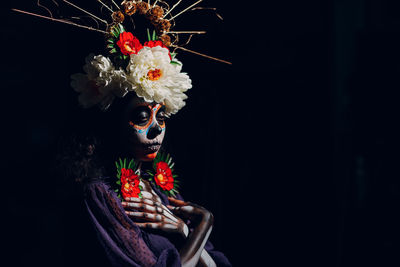 Woman wearing mask against black background