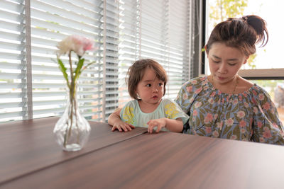 Mother and daughter sitting at table restaurant 