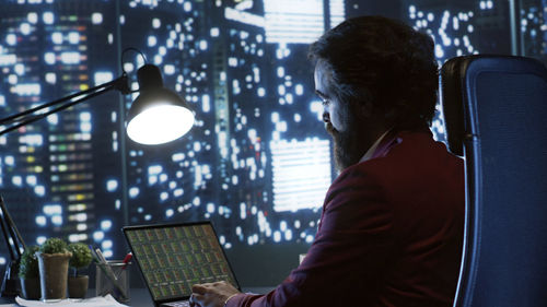 Rear view of woman using laptop at airport