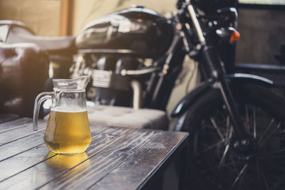 Beer pitcher by motorcycle on table