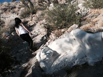 Tilt rear view image of woman walking on rocky footpath