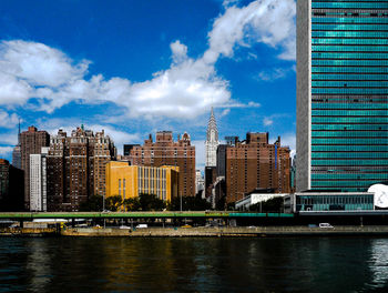 City at waterfront against blue sky