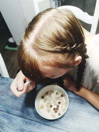 High angle view of girl eating food at home