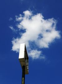 Low angle view of billboard against blue sky