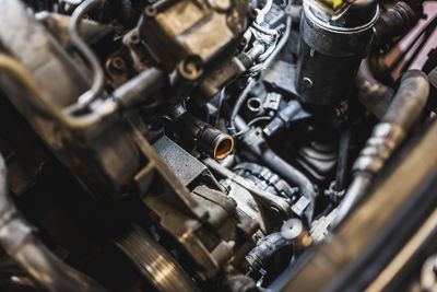 Soft focus of corroded pipe installed inside engine of broken car under repair in professional garage