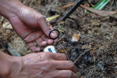 Cropped hands repairing pipe