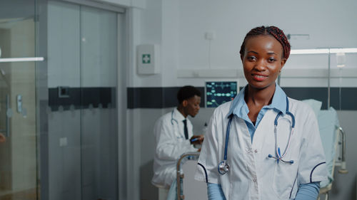 Portrait of smiling female doctor standing in hospital