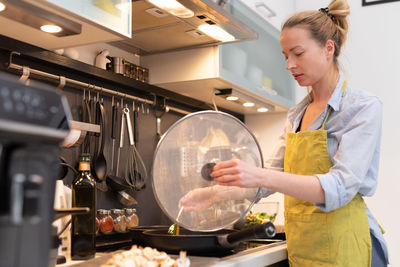 Young woman preparing food in kitchen