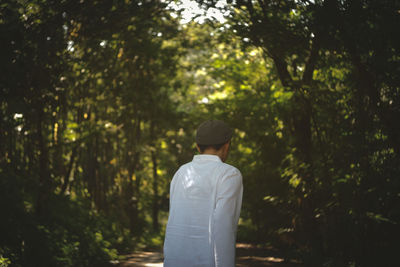 Rear view of man standing in forest