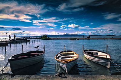 Boats moored in sea against sky