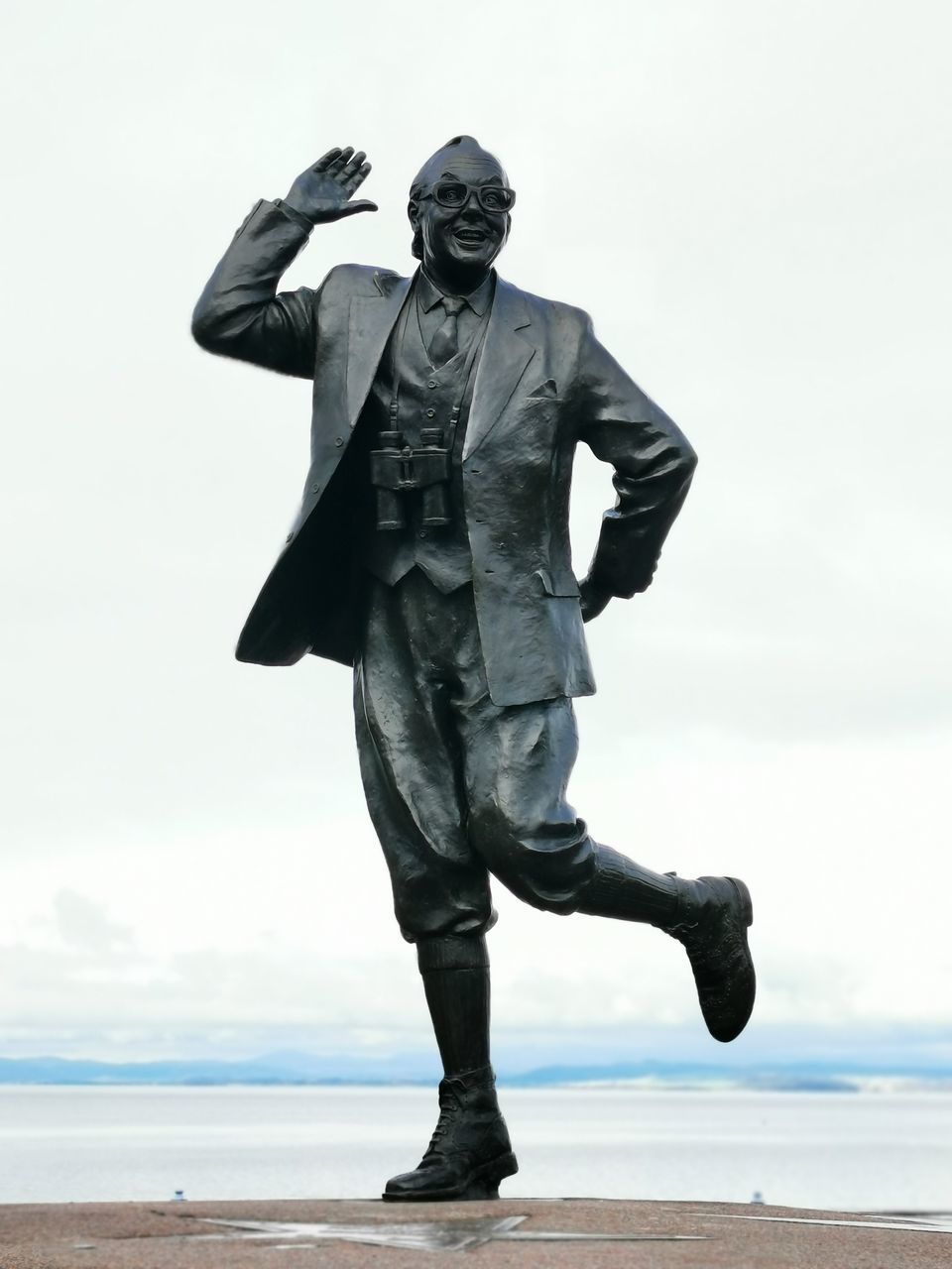 LOW ANGLE VIEW OF STATUE OF MAN AT BEACH