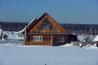 Houses on snow covered landscape against sky