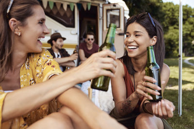 Portrait of female friends having drinks while camping