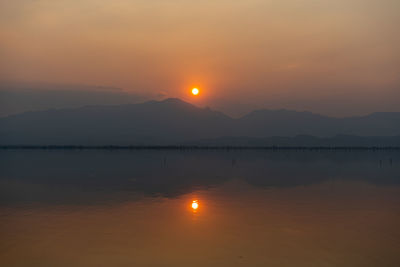 Scenic view of lake against romantic sky at sunset