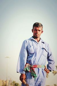 Portrait of smiling man standing against clear sky