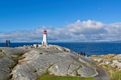 Lighthouse by sea against sky