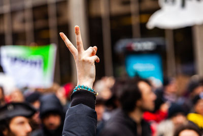 Midsection of woman with arms raised in city