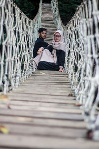 People sitting on footbridge