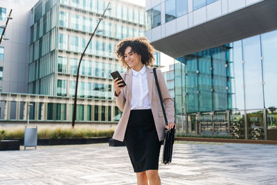 Portrait of young woman standing in city