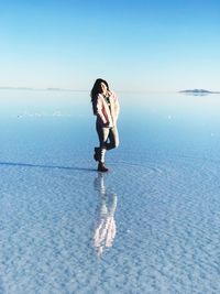 Woman in sea against sky