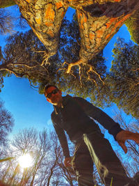 Low angle view of young man against sky