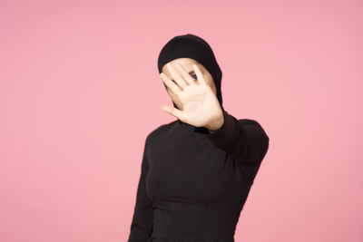 Person standing against pink background