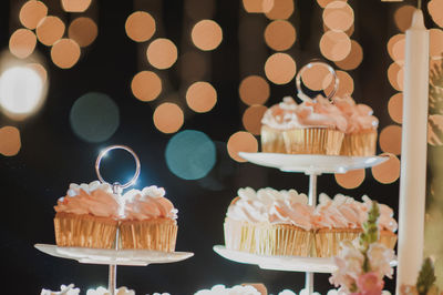 Close-up of cupcakes against illuminated lights at night