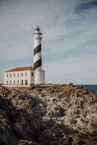 Lighthouse on beach against sky