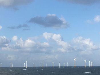 Wind turbines on land against sky