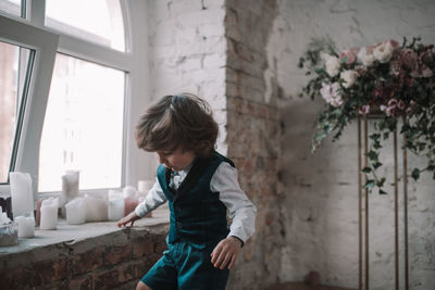 Full length of boy standing against wall