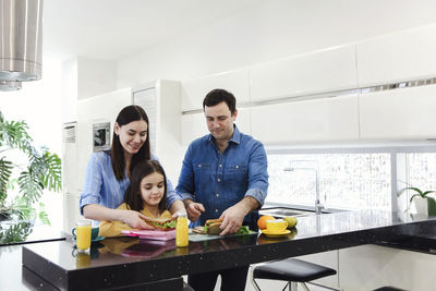 Happy family packing lunch in box