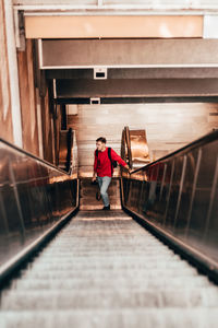 High angle view of man standing on escalator