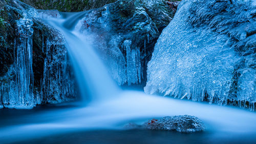 Waterfall cascades in cold winter temperatures. frozen waterfall.