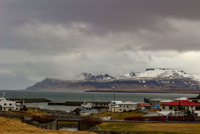 Scenic view of sea by buildings against sky